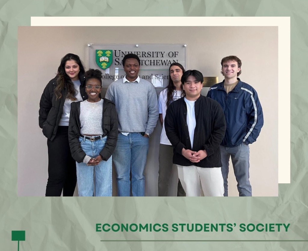 Pamimo with five members of the Economics Students Society in front of a University of Saskatchewan sign